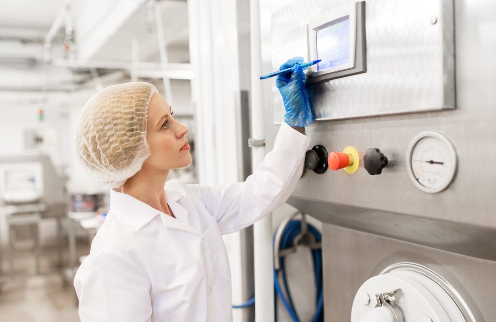 Woman working in factory on a touchscreen monitor