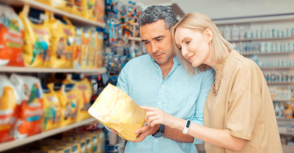 Couple reading pet food ingredients in retail environment.